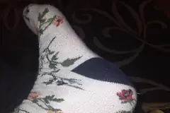 Крак в бял чорап на цветя с тъмна пета