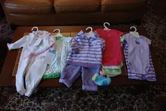 Бебешки и детски дрехи на закачалки, подредени една до друга
