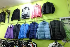 Якета с качулка и пухени якета, закачени на стена